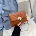 Brown quilted crossbody bag with gold chain strap and metal lock shown in hand - Dark Brown