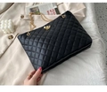Detalle del bolso de cubo acolchado negro con cadena dorada y cierre de mariposa - Negro