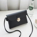 Chic black faux leather crossbody bag with pebble texture and gold rotating lock clasp - Black