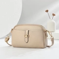 Detail of beige litchi grain leather crossbody bag featuring dual zippers and gold hardware - Light Khaki