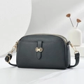 Detail of lychee textured leather crossbody bag with golden bow clasp and double zippers - Dark Gray
