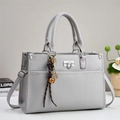 Détail du sac à main gris en cuir texturé avec des breloques décoratives - Gris