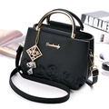 Elegant black lychee leather handbag with floral embroidery and gold metal handle for women - Black