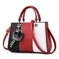 Bolso de mano tricolor con amuleto de zorro y pompón de peluche, vista lateral de 45 grados - Burdeos