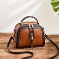Bolso bandolera vintage marrón con forma de concha y flecos sobre madera - Caramelo