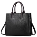 Borsa tote vintage in pelle nera con manici marroni, scatto professionale da studio - Nero