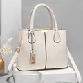 Minimalist beige lychee grain leather tote bag with gold hardware on white pedestal - White
