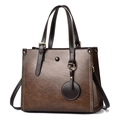 Retro brown leather tote bag with white stitching and round pendant detail - Brown
