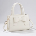 White faux leather crossbody bag with a large bow detail and gold hardware - White