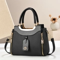 Bolso tote negro trenzado con cremalleras doradas y correa de hombro ajustable en un soporte - Negro
