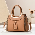 Detail der braunen Handtasche mit Webstruktur, goldener Hardware und Schultergurt - Erdgelb