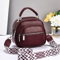 Detailed view of dark red lychee leather tote bag with triple zipper compartments - Burgundy