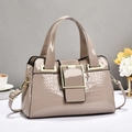 Détail du cuir gaufré crocodile et de la grande boucle dorée sur le sac à main chic - Kaki