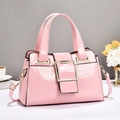 Pink croc-embossed patent leather handbag with gold buckle and elegant city lifestyle setup - Pink