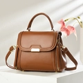 Brown vintage leather crossbody bag with white stitching and gold buckle on a white stand - Earthy Yellow