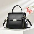 Classic black crossbody bag with white stitching and gold hardware on white display - Black