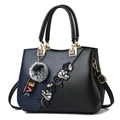 Black and blue contrast tote bag with floral embroidery and a grey faux fur pom pom charm - Classic / Dark Blue