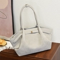 Minimalist large grey matte tote bag with gold buckle on wooden cabinet in home setting - Gray