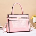 Detail of pink crocodile texture handbag with golden clasp and adjustable strap - Pink