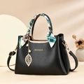 Elegant black leather tote bag with decorative silk scarf handle and golden leaf charm - Black