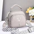 Detail of grey crossbody bag featuring crocodile texture, silver V-logo and wide strap - Gray