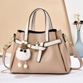 Elegant beige crossbody bag with bow charm, lychee grain leather and gold hardware - Khaki