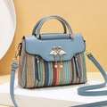 Chic woven tote bag with light blue leather trim and golden swan pearl clasp detail - Blue