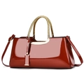 Détail d'un sac polochon en cuir verni rouge avec poignée dorée et bandoulière réglable - 34x11x16cm / Rouge
