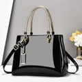 Glossy black patent leather tote bag with elegant gold snake-texture handles and hardware - Black