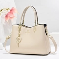Elegant cream leather tote bag for women featuring a gold heart pearl pendant and top handles - Off-white