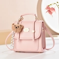 Pink PU leather backpack with decorative straps and a plush brown bear keychain - Solid Color / Pink
