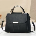 Detail einer schwarzen Lederhandtasche mit goldenen Rundgriffen und vertikalen Nähten - Schwarz