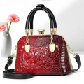 Sac rouge brillant à texture crocodile avec poignées noires et ferrures dorées - Bordeaux