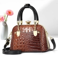 Detail of crocodile-textured shell bag with gold hardware and large crystal clasp - Earthy Yellow