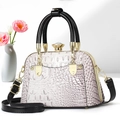 Detailed view of pink crocodile pattern shell bag with black handle and jewel clasp - Purple