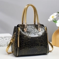 Sac à main luxe en cuir noir avec gaufrage floral doré et poignées rondes - Doré
