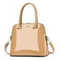 Detail view of glossy patent leather texture and gold hardware on beige dome satchel bag - Khaki
