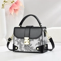 Elegante borsa a mano paisley con finiture in pelle nera e dettagli in metallo dorato lucido - Nero
