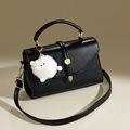Minimalistische schwarze Handtasche aus Narbenleder mit goldener Schließe und Plüschanhänger - Schwarz