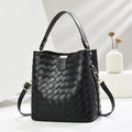 Schwarze gewebte Beuteltasche mit goldenen Details vor minimalistischem Hintergrund - Schwarz