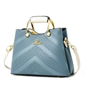 Fashionable hazy blue crossbody bag with cream handles and elegant V-shaped embossing - Blue