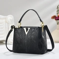 Bolso tipo cubo negro con efecto cocodrilo, logotipo V dorado y correa ajustable - Negro