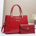 Detalle de un set de bolsos rojos con relieve de cocodrilo y asas metálicas doradas - Rojo