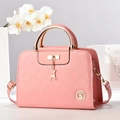 Pink patent leather quilted handbag with gold handle and deer charm on white background - Pink