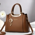 Brown lychee leather handbag with golden hardware and star-moon pearl charm detail - Coffee