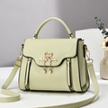 Pistachio green textured leather handbag with swan metal clasp and pearl detail - Green