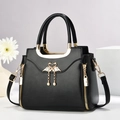 Elegant black leather handbag with gold swan clasp and pearl tassel on white background - L24 W12 H20cm / Black