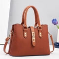 Elegant brown macaron handbag with vertical ribbed texture and gold lock on white background - Earthy Yellow