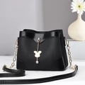 Elegant black pleated bucket bag with gold chain strap and rabbit charm on grey background - Black