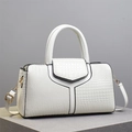 Borsa bianca in pelle di coccodrillo con bordi neri su piedistallo minimalista - Bianco